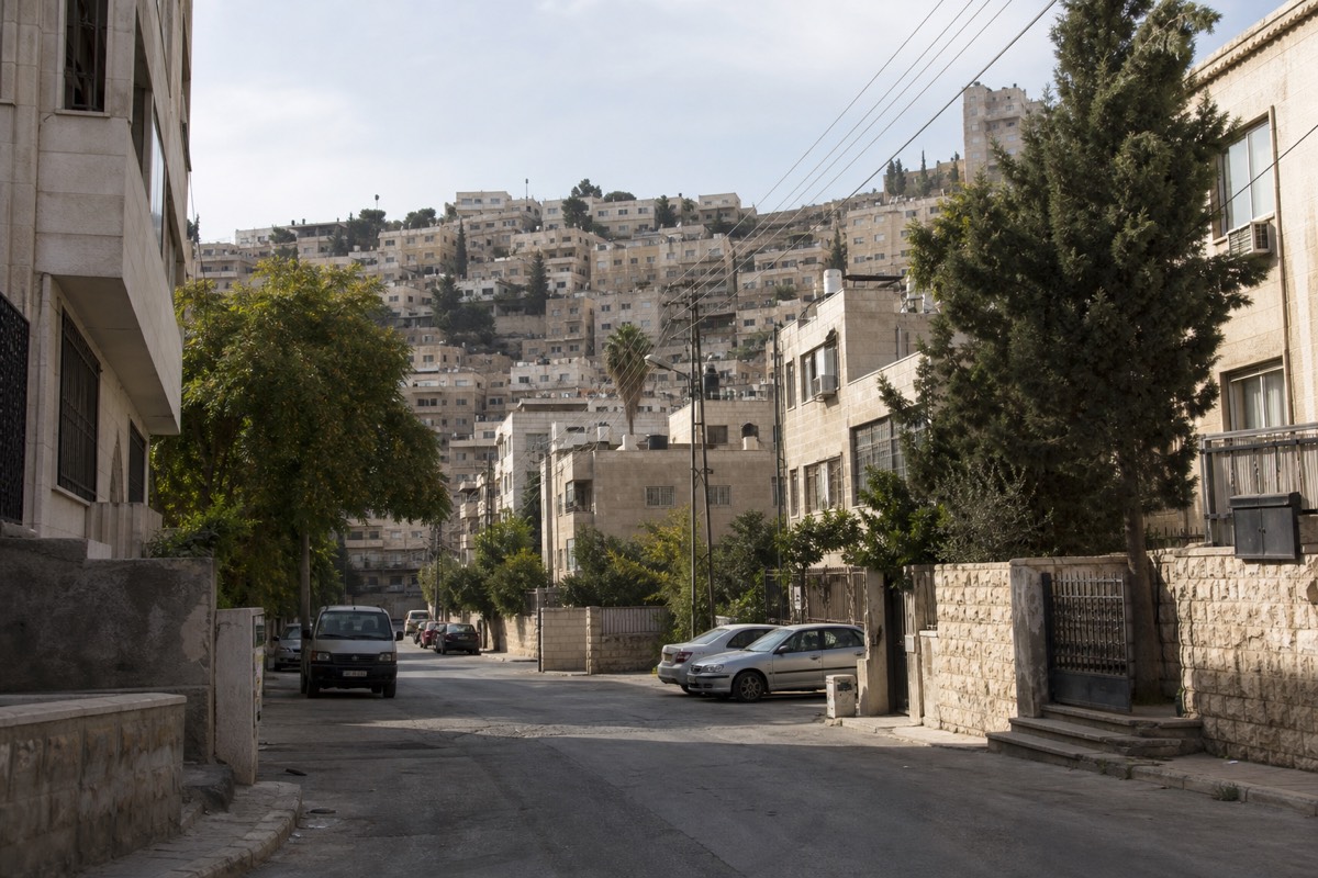 A quiet street in Amman, Jordan, with the hills of the city rising in the background