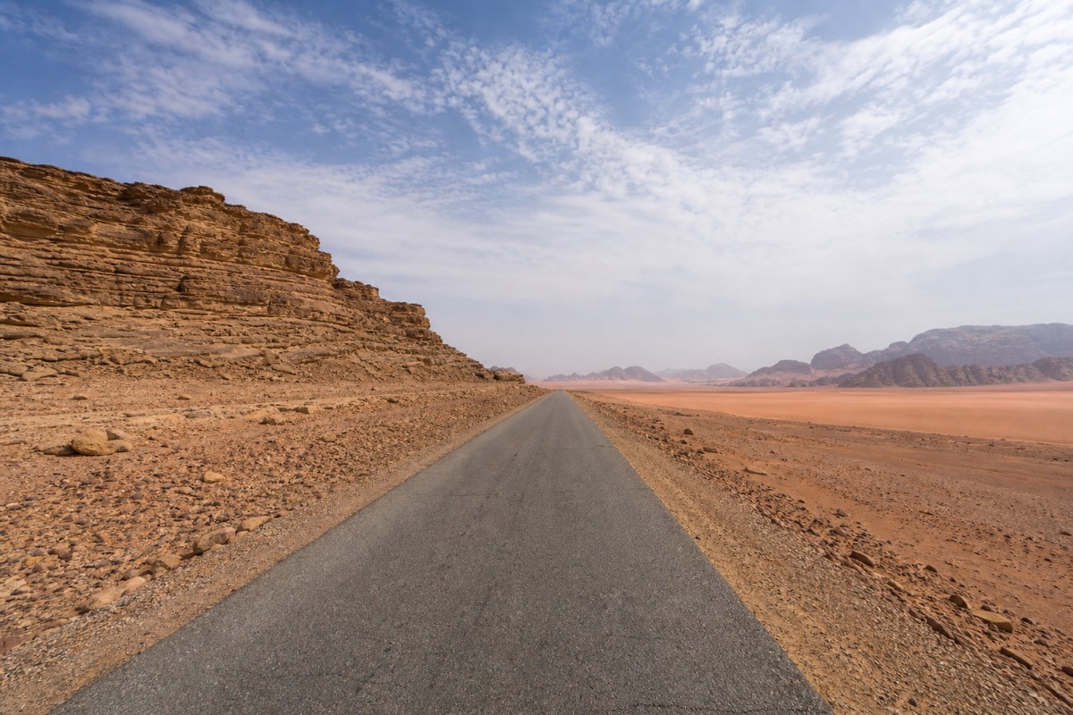 A split view contrasting Petra's carved sandstone Treasury with the open red desert of Wadi Rum